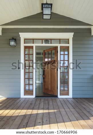 Vertical shot of wooden front door  of an upscale home with windows/Exterior shot of a Wooden Front Door