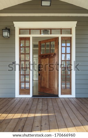 Vertical shot of wooden front door  of an upscale home with windows/Exterior shot of an open Wooden Front Door