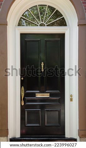 Closeup of Black Front Door with White Door Frame and Archway Window