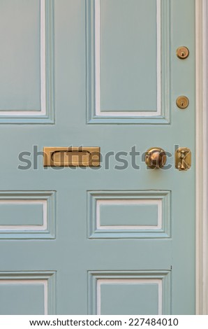 Close Up of Pale Blue Front Door with White Surrounding Door Frame and Windows