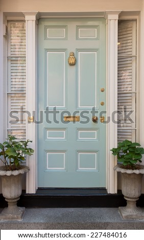 Pale Blue Front Door with White Surrounding Door Frame and Windows with Potted Plants