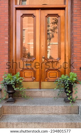 Close Up of Natural Wood Double Front Doors with Inset Windows and Greenery