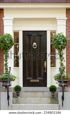 Black Front Door with White Portico and Greenery