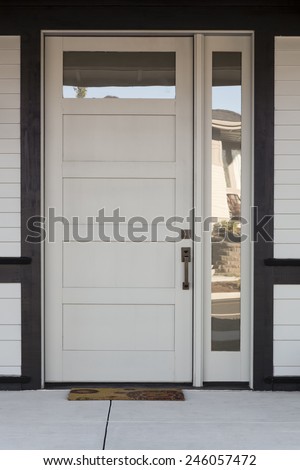 Close Up of White And Black Front Entryway with White Siding, a White Front Door, and Black Framing