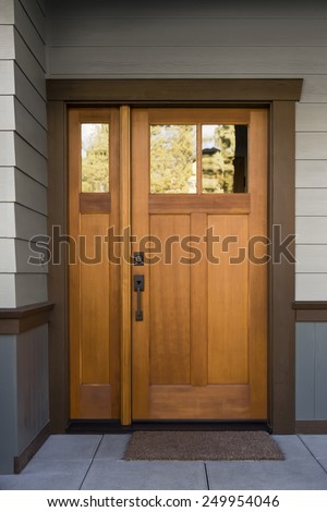 Natural Wood Front Door on Grey and Blue Siding Exterior with Large Slate Tiles and Doormat