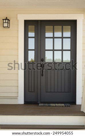 Close Up of Black Front Door on House with Yellow Exterior Siding