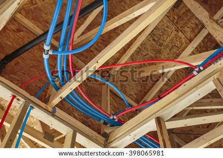 New Home Construction with PEX Plumbing pipes and exposed beams.
