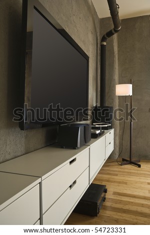 Large flat panel television and entertainment center in a modern loft. Vertical shot.