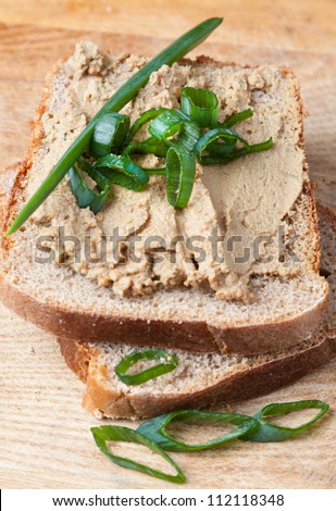 Open sandwich on sliced brown bread with liver pate garnished with fresh herbs