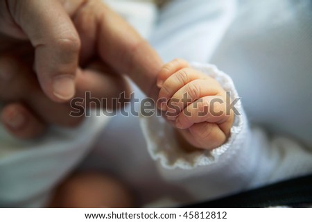 close-up adult hand taking hand baby