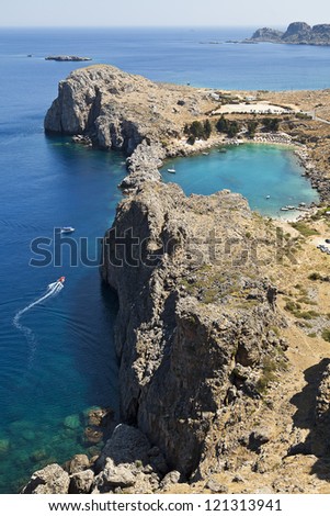 A blue lagoon near the town of Lindos on the Greek island of Rhodos highlights the deep blue waters.