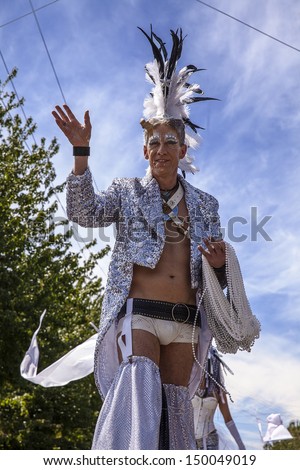 SEATTLE, WA - JUNE 22, 2013: The Master Of Ceremonies in a fancy coat, feathered hat and underwear towers overhead as he opens the 2013 Fremont Summer Solstice Parade in Seattle on June 22, 2013.