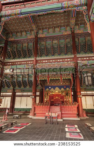 SEOUL, SOUTH KOREA - APRIL 27, 2012: The royal throne room in the interior of Geunjeongjeon Hall in the Gyeongbokgung Palace complex is covered with ornate bright red and green decorations.