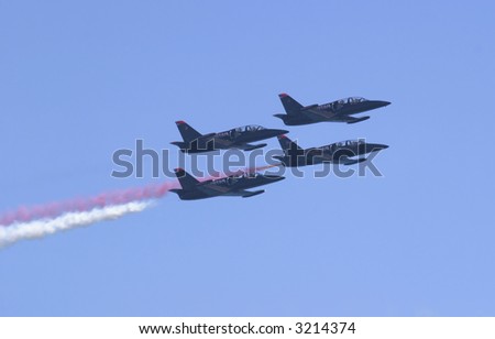 A tight formation of four jets performing aerial maneuvers at high speed. The Patriot Jets performed in Seattle at the SeaFair festival.