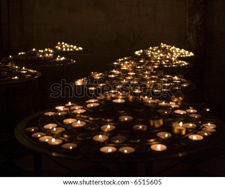 Hundreds of little tea light candles are lit at Notre Dame cathedral in Paris to give emphasis to people\'s prayers. The candles were flickering through the exposure which results in a soft image.