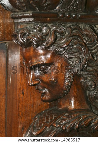 A detailed element of a decorative carved wood figure used as support for a fireplace mantel in the Irish Parliament House in Dublin, Ireland.