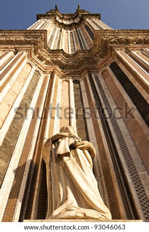 A view looking upwards to the top of one of the twin bell towers of the main cathedral, the Duomo, in Orvieto. The extreme perspective foreshortens the tower.