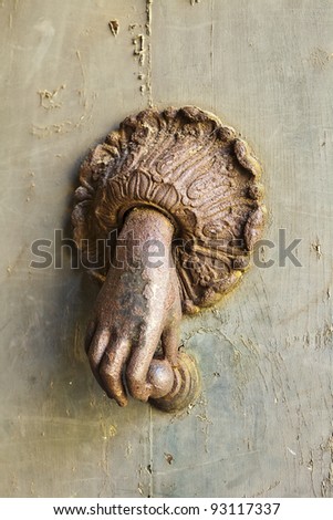 A mysterious hand comes out of the door to hold a knocker. This rusty ornamental fixture was seen on a door in Orvieto, Italy.