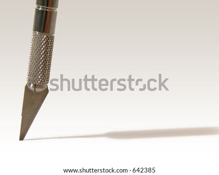 cutting blade stuck in a table upright, casting a long shadow. set against a white background