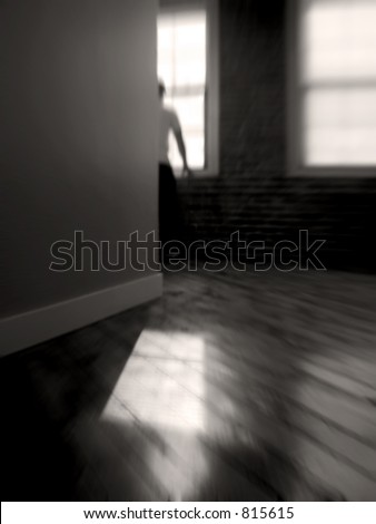 blurred interior scene of a solemn man staring out of a window - reflections on the wood floor