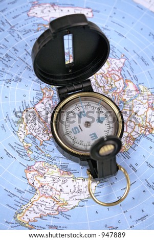 open compass resting on a map of the world