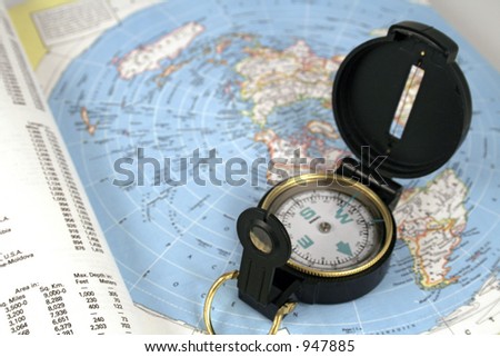 open compass resting on a map of the world