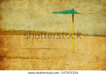 Stylized photo of a lonely standing old umbrella on a wild beach