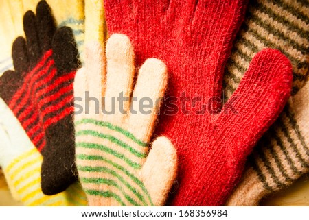 lot of knitted gloves on wooden background