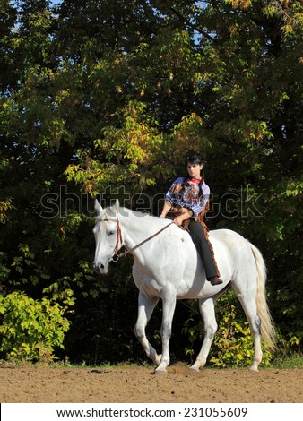 Beautiful girl dressed as a western riding a horse bareback