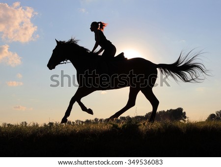 Equetsrian riding her hHorse at sunset