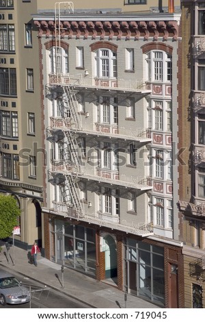An old downtown apartment building as view from another building across the street.