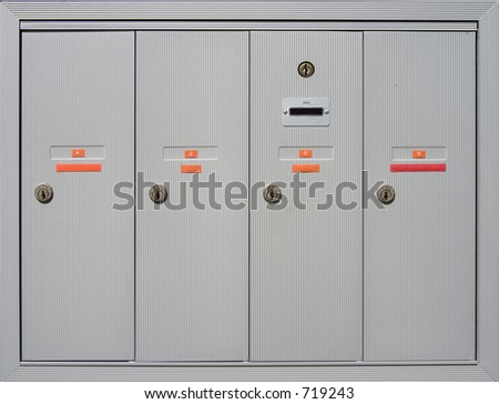 A group of mailboxes doors outside of an apartment building.