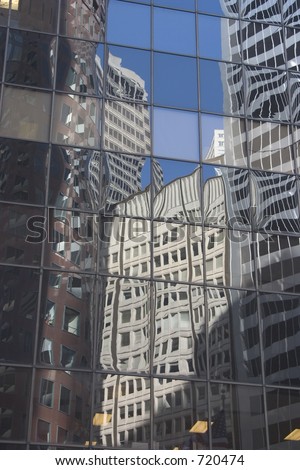 Buildings reflected in the glass face of a building.