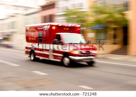 A fire rescue vehicle blazes by, it\'s sirens whaling.  An intensional zoom blur gives a feeling of a rushed tension to the scene.
