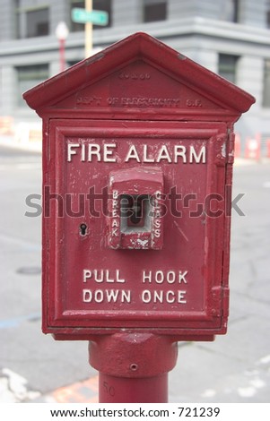 A public sidewalk fire alarm that looks like it\'s seen some use.