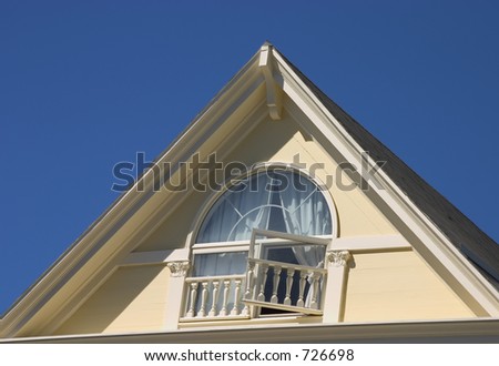 Peeked victorian roof with an open window on it\'s face.