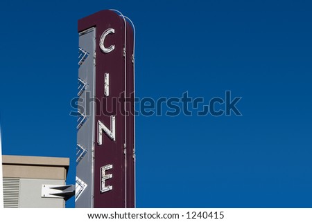A retro â€œCineâ€� sign, outside of a movie theater.