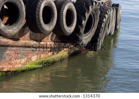 Old tires serve as bumpers for a tug boat.