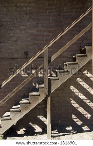 Wooden steps leading up the side of an old brick building.