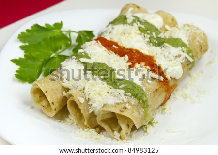 Tacos Dorados Mexican Dish. These are made of chicken meat and salsa with shredded cheese and sour cream.