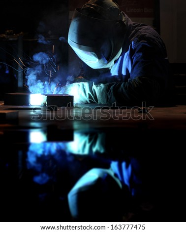 industrial welding mirrored on the work table