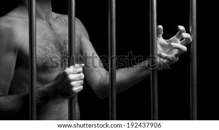 prisoner behind bars of a dark prison
