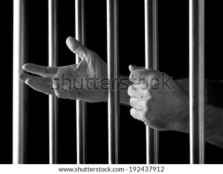 prisoner behind bars of a dark prison