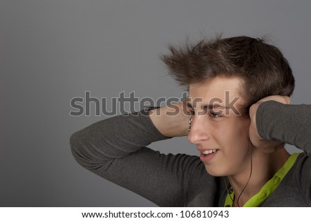 Young man listens to music with the music player through headphones