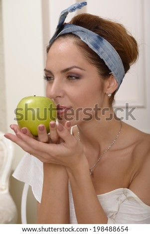 Yung woman in white blouse with a green apple in hand