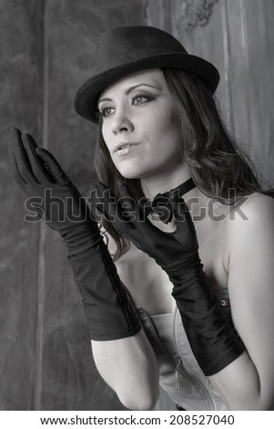 Black and white portrait of a young woman in a black hat on an abstract background