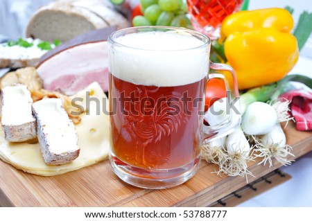 Meal concept with bread, onion, tomatoes, cheese, beer, bacon and pepper.