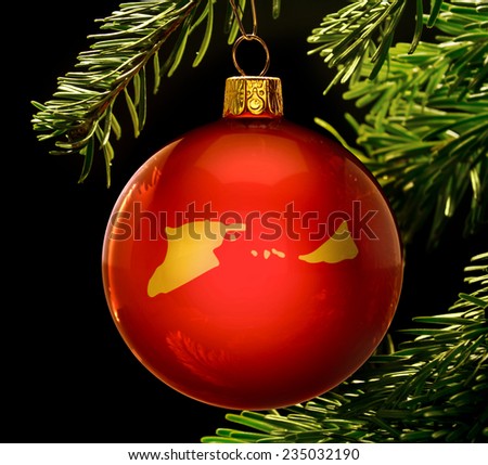 A red bauble with the golden shape of  Midway Islands hanging on a christmas tree isolated on black.(series)