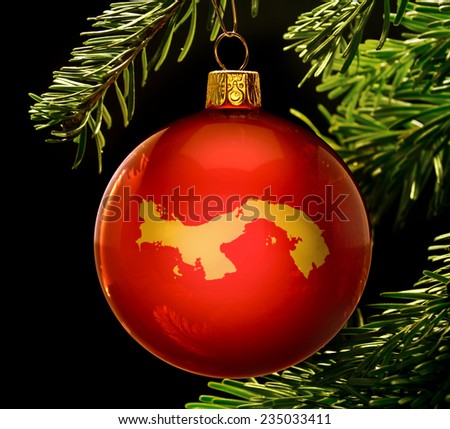 A red bauble with the golden shape of  Panama hanging on a christmas tree isolated on black.(series)