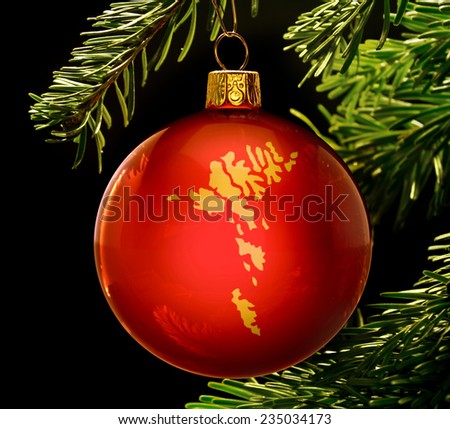 A red bauble with the golden shape of  Faroe Islands hanging on a christmas tree isolated on black.(series)